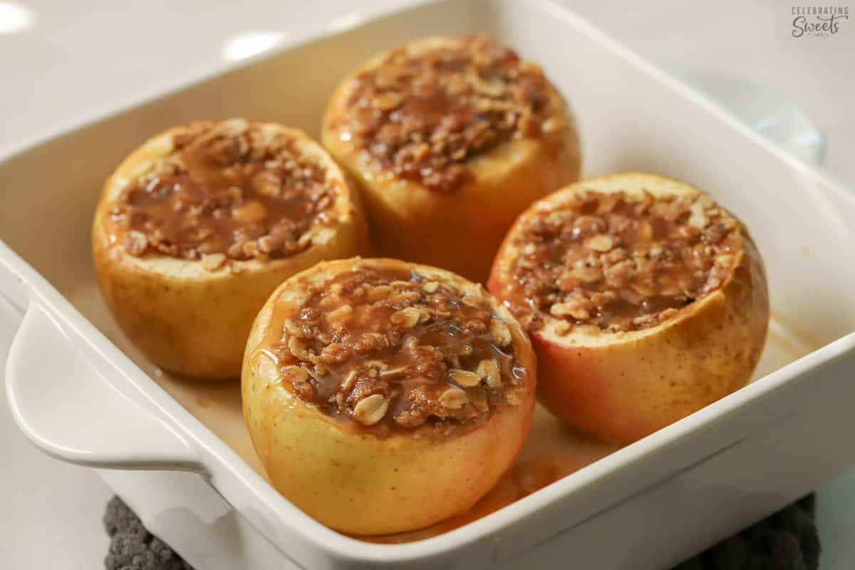 Baked apples topped with caramel in a baking dish.