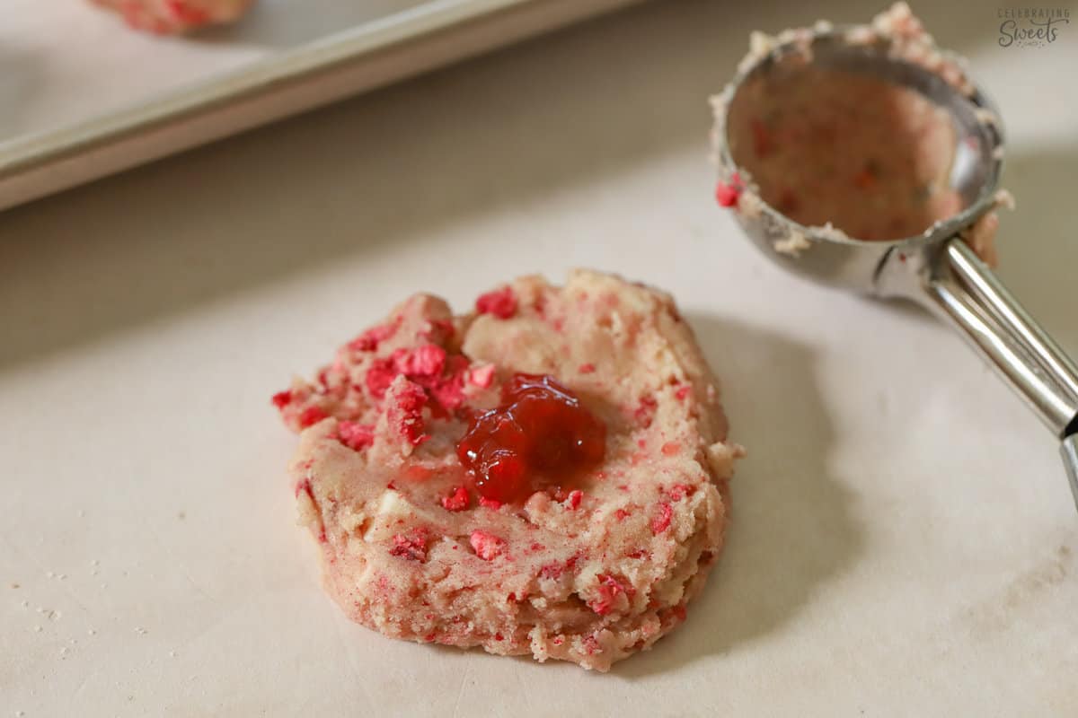 Cookie dough with a dollop of raspberry jam in the middle.