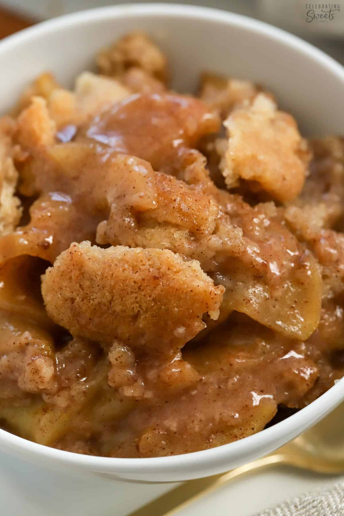 Closeup of apple cobbler in a white bowl.