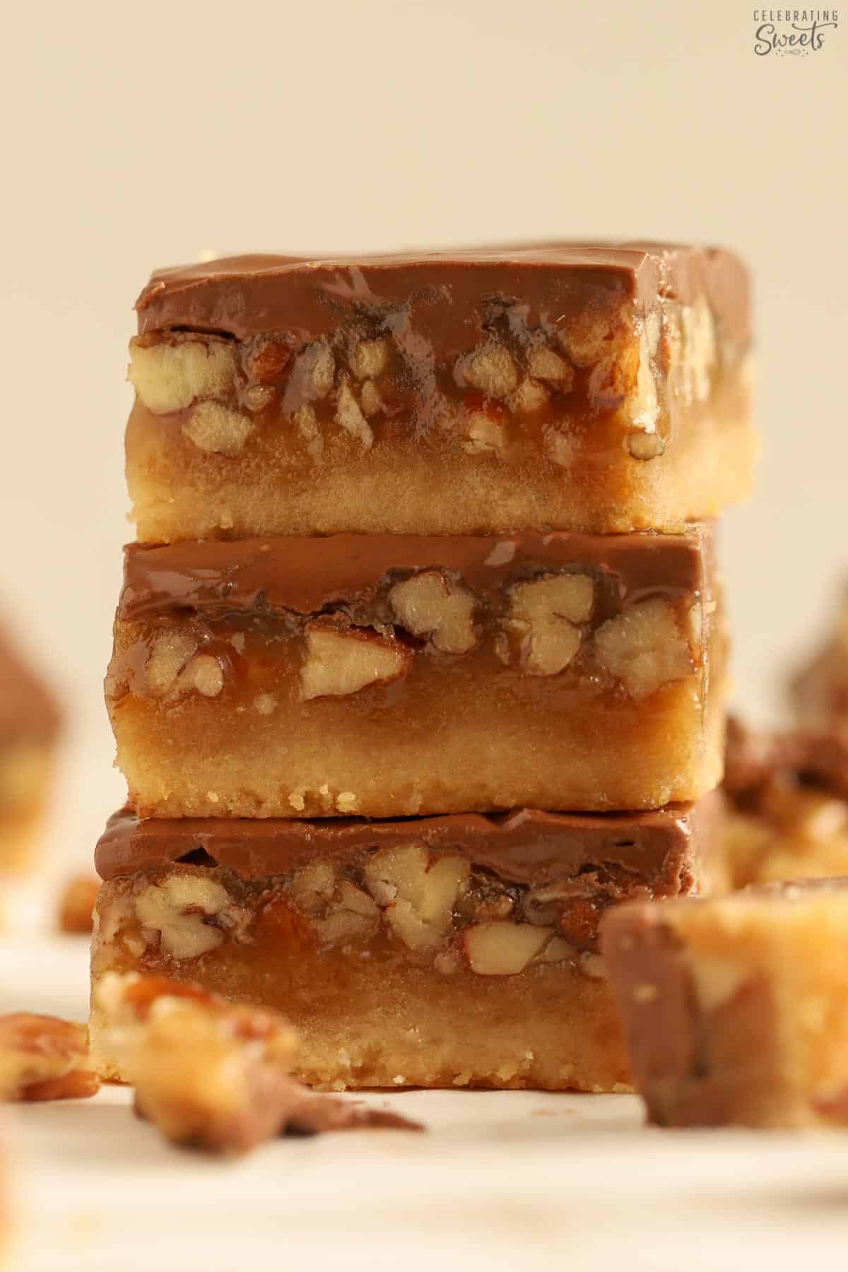 Stack of three chocolate caramel pecan bars.