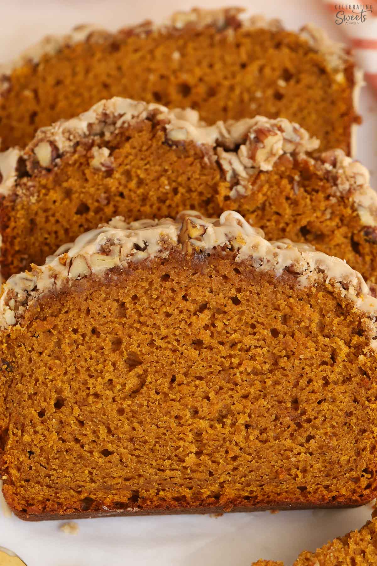 Three slices of pumpkin bread on parchment paper.