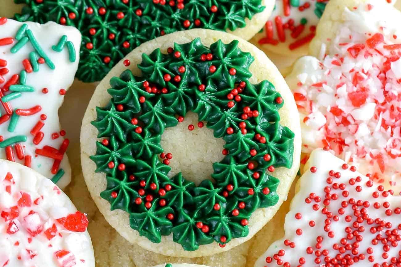 Sugar cookie topped with green frosting and red sprinkles to look like a holiday wreath.