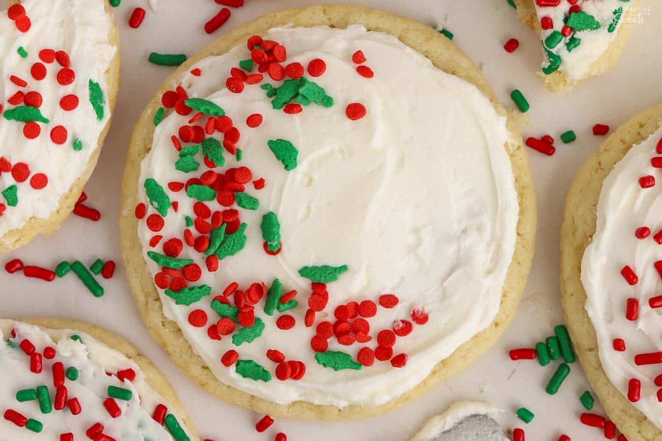Round sugar cookie with white frosting and red and green sprinkles.