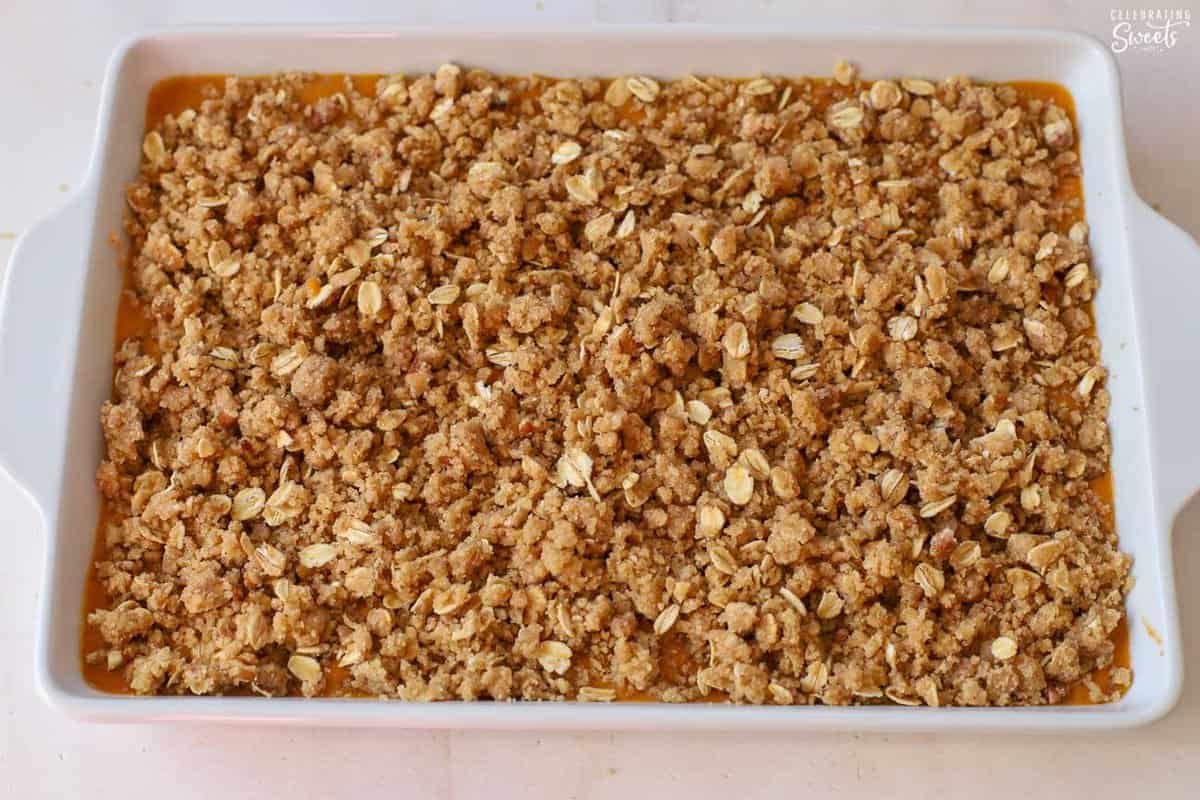 Unbaked pumpkin crisp in a white baking dish.
