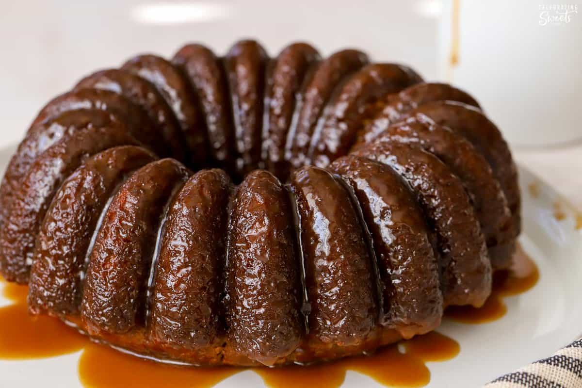 Sticky toffee pudding bundt cake on a white plate.