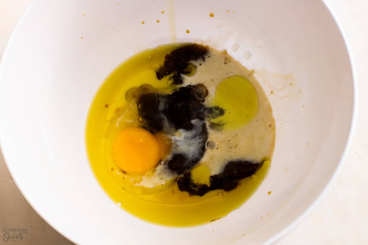 White bowl filled with egg, brown sugar, milk, and vanilla.