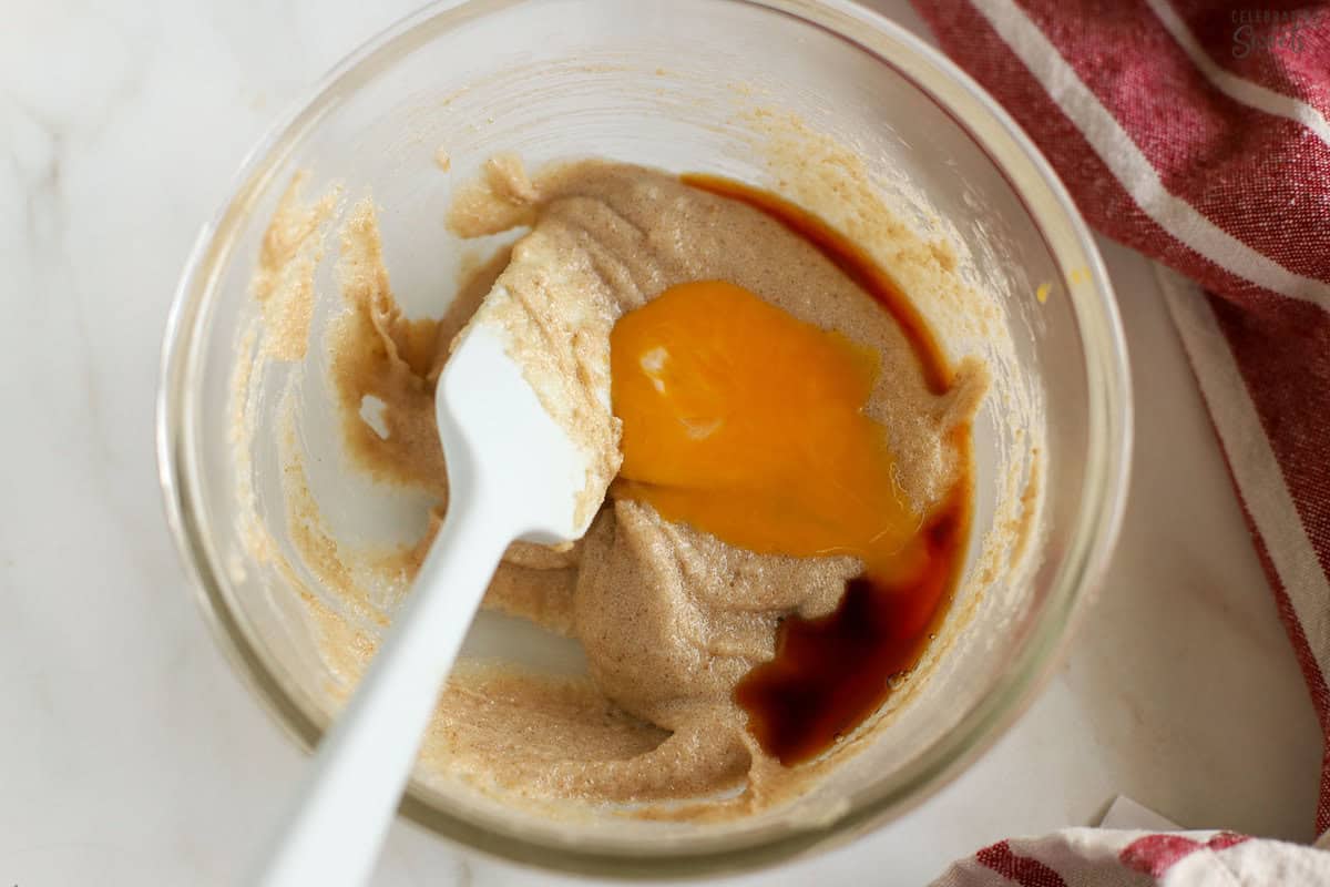 Cookie dough with butter, sugar, and egg in a glass bowl.