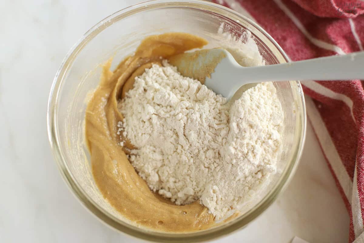 Cookie dough and flour in a glass bowl.