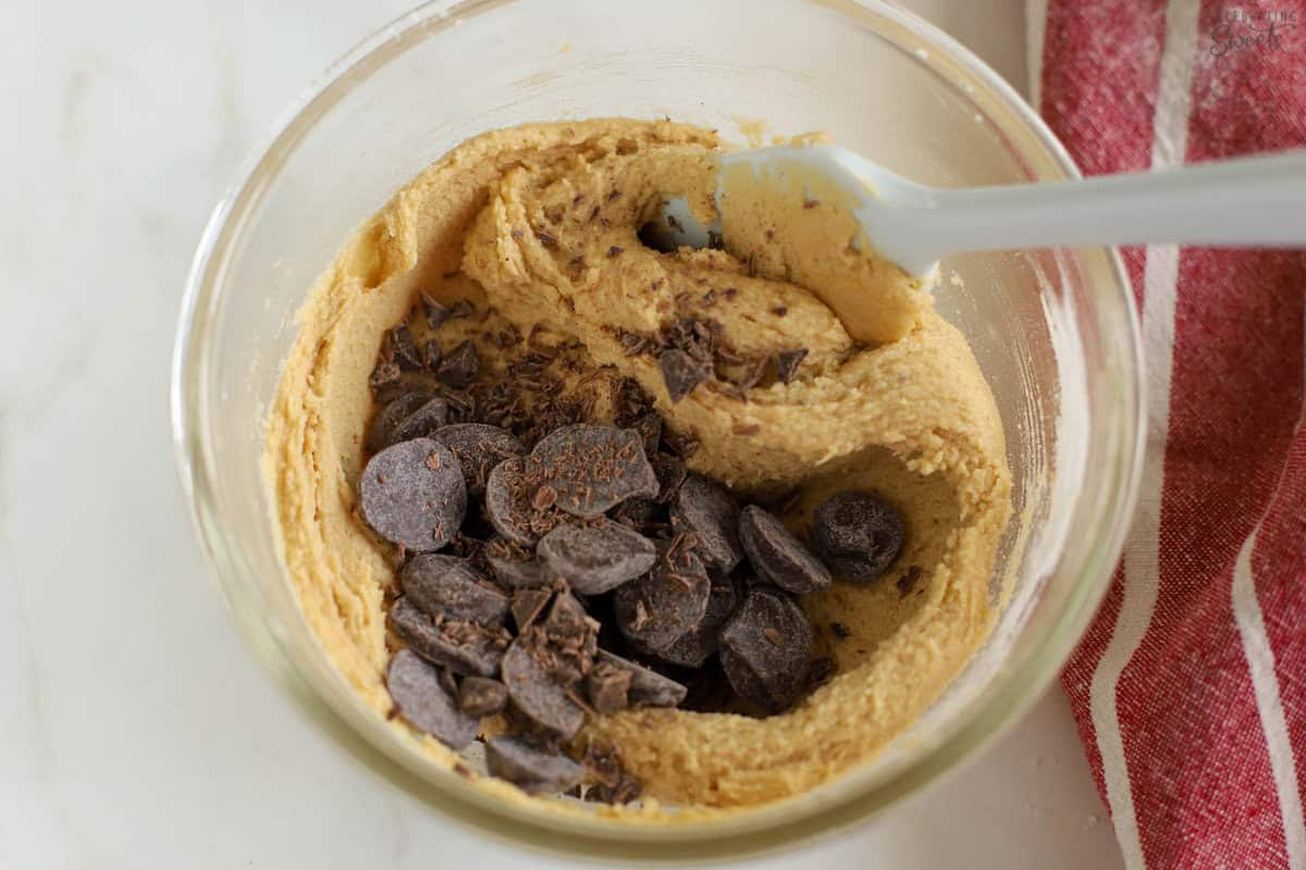 Chocolate chip cookie dough in a glass bowl.