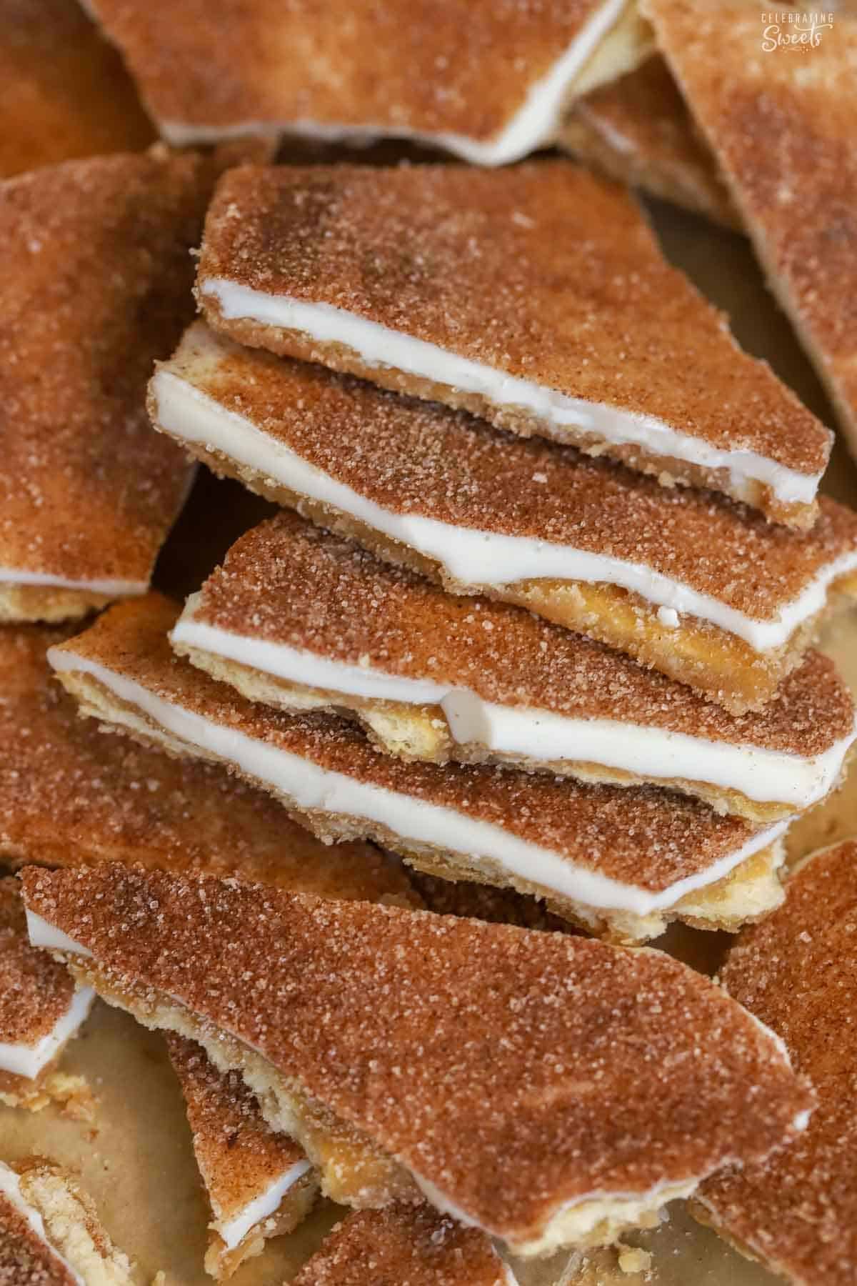 Five pieces of churro toffee overlapping on parchment paper.