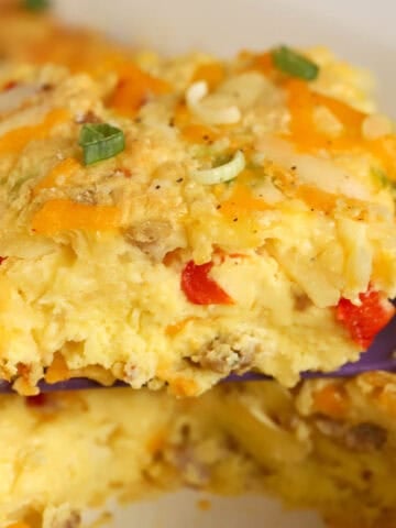 A serving of egg casserole on a purple spatula.