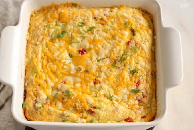 Egg casserole in a white square baking dish.