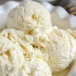 Four scoops of vanilla ice cream in a white bowl.