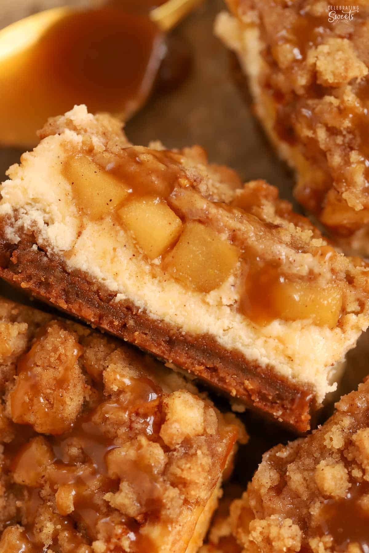 Closeup of an apple cheesecake bar with a gold spoon in the background.
