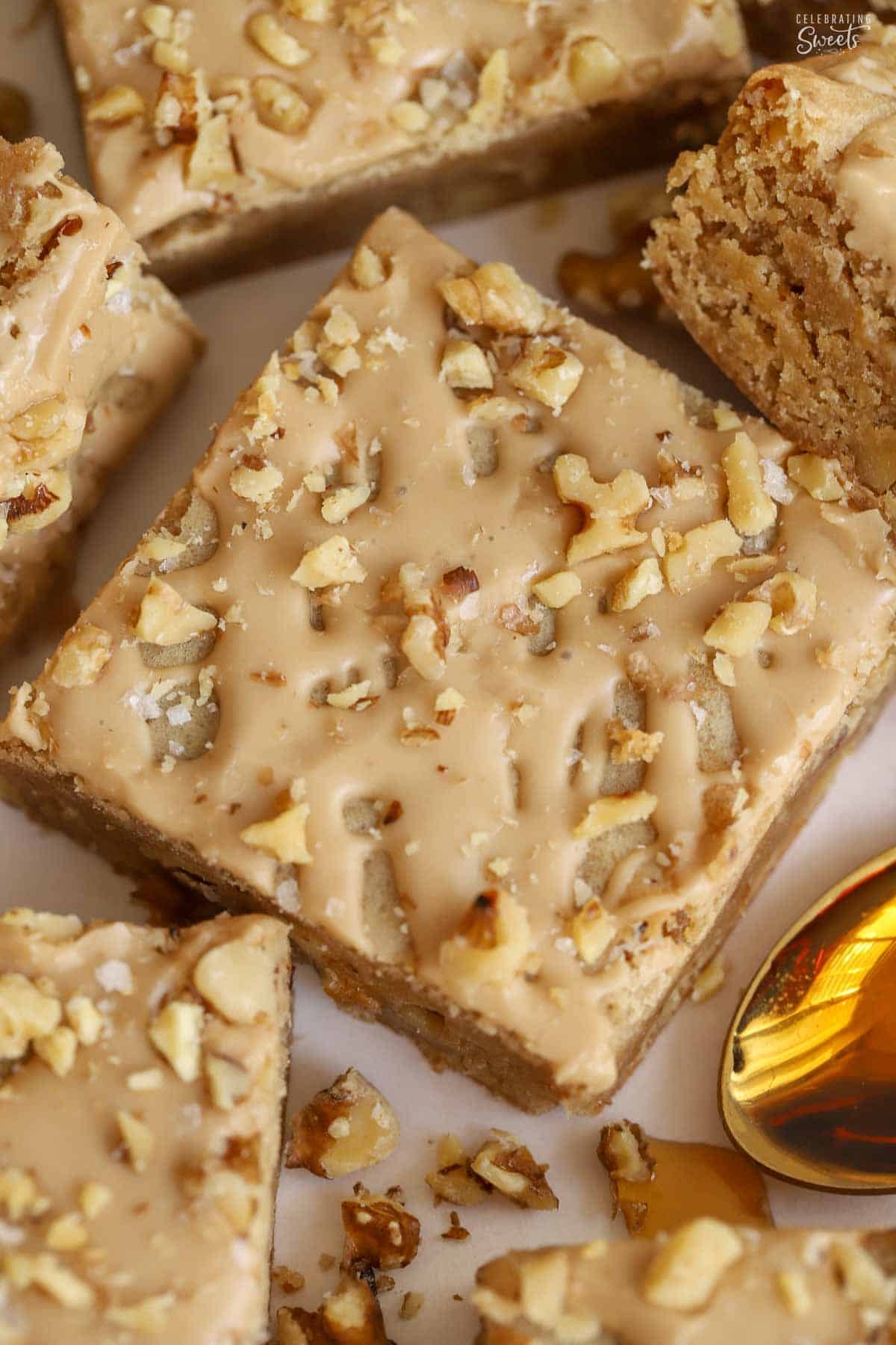 Maple walnut bar on parchment paper next to a gold spoon.