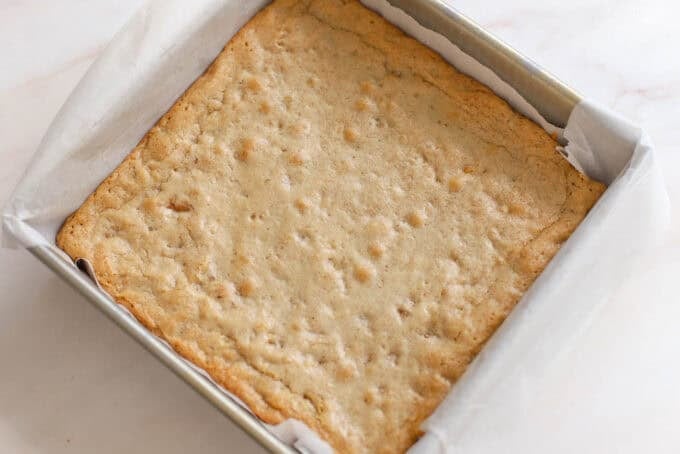 Maple walnut bars in a square pan lined with parchment paper.