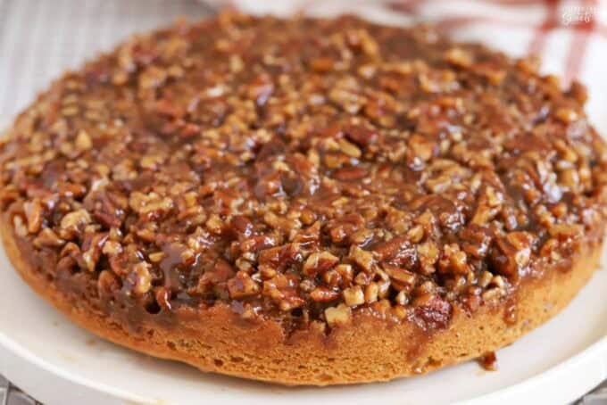 Round pecan pie cake on a white plate.