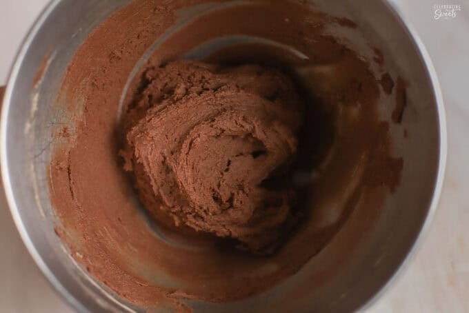 Chocolate cookie dough in a metal bowl.