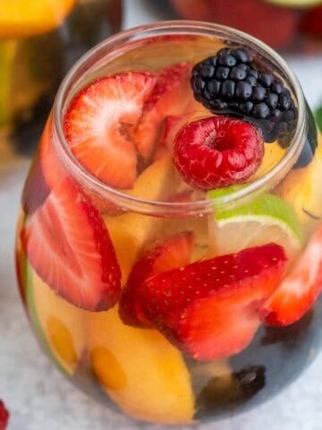 White sangria and fresh fruit in a stemless wine glass.