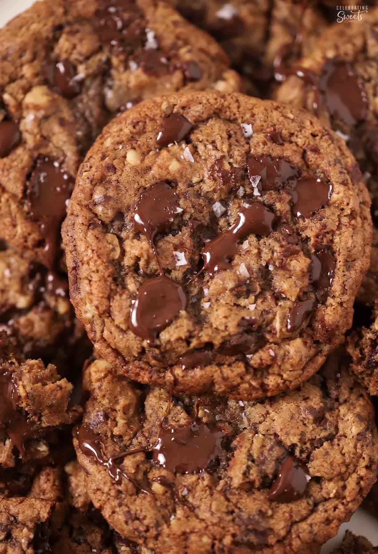 Closeup of an oatmeal chocolate chip cookie topped with melted chocolate bits and flaky sea salt.
