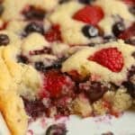 Cherry berry spoon cake in a white baking dish.