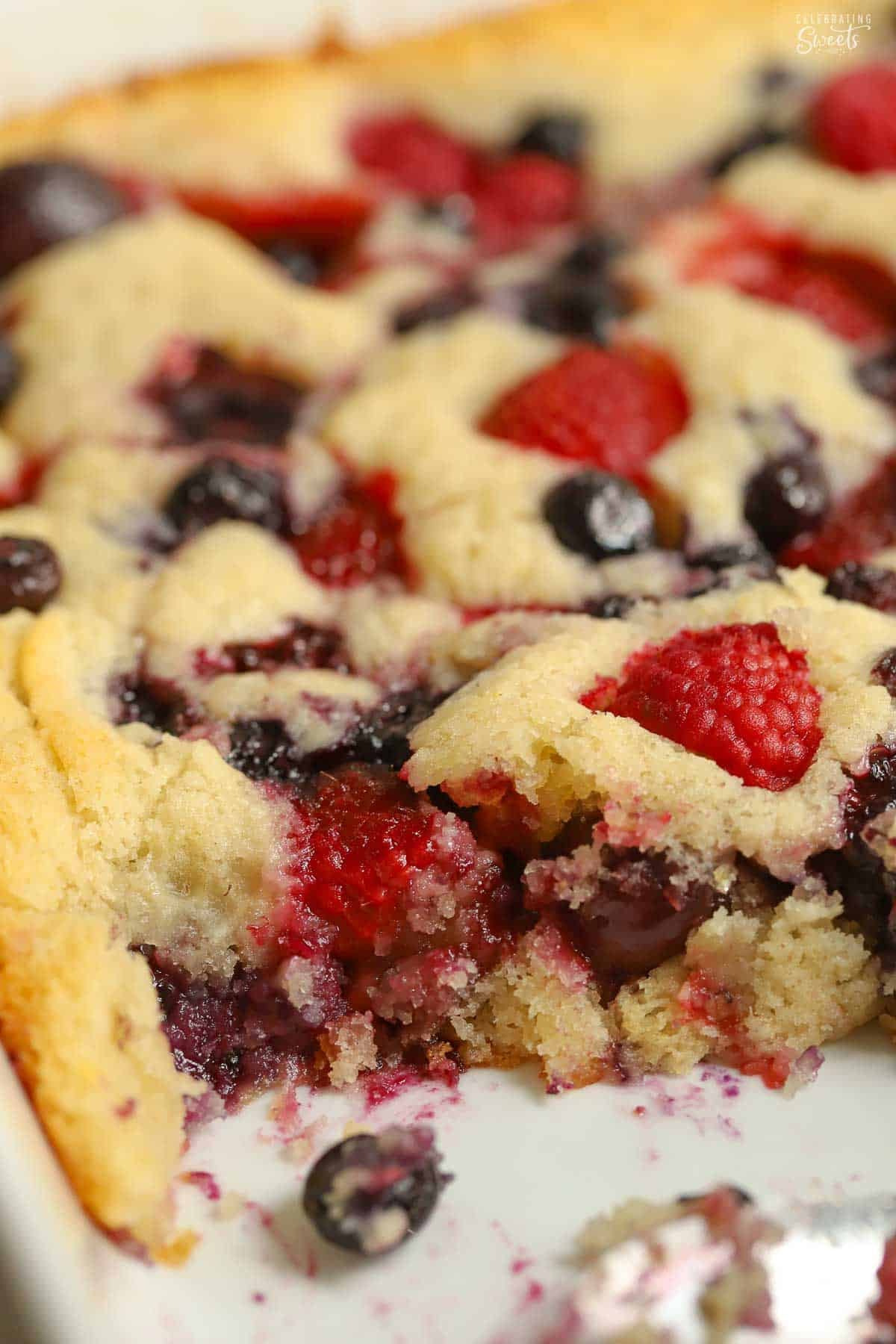 Cherry berry spoon cake in a white baking dish.