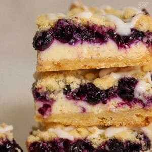 Closeup of a stack of three lemon blueberry crumb bars.