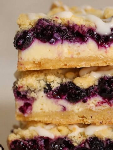 Closeup of a stack of three lemon blueberry crumb bars.