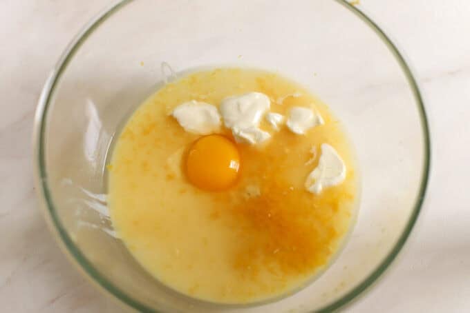 Egg yolk, sour cream, lemon juice, and sweetened condensed milk in a glass bowl.