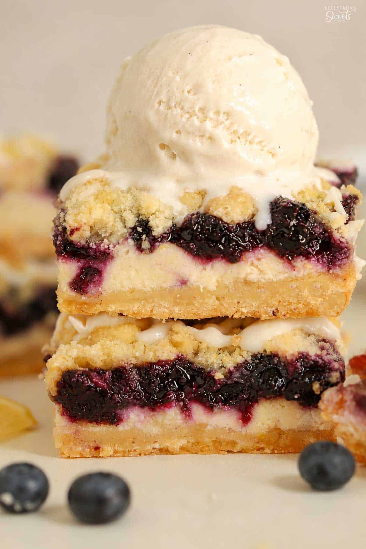 Stack of two lemon blueberry crumb bars topped with a scoop of vanilla ice cream.