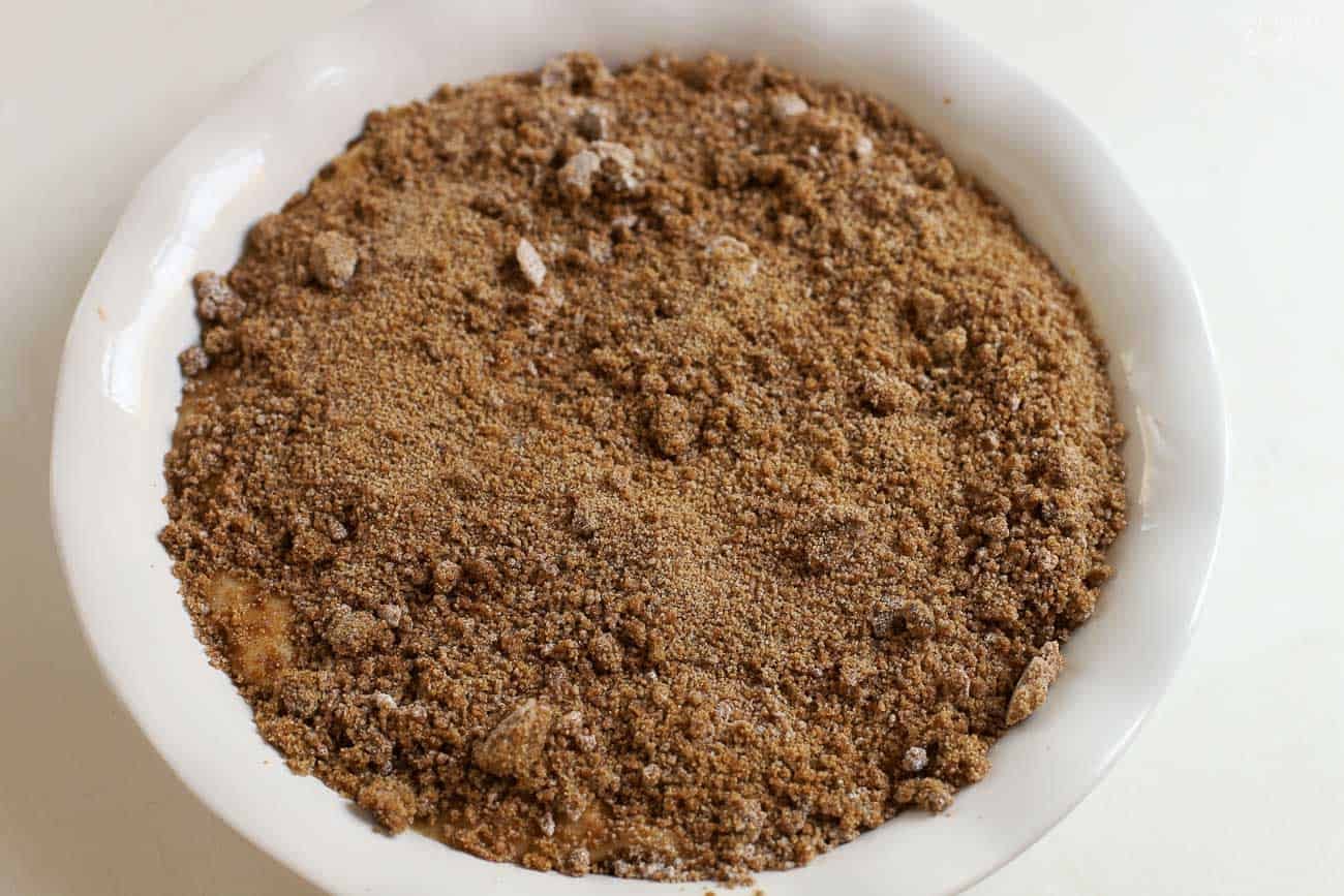 Brown sugar and cornstarch sprinkled over cake batter in a white round baking dish.